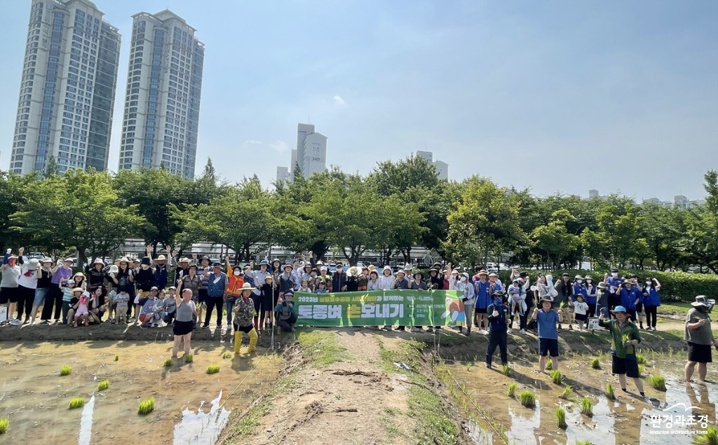 4. 상동호수공원 ‘토종벼 손모내기’ 프로그램에 참여한 시민들이 활짝 웃으며 기념촬영을 하고 있다..jpg